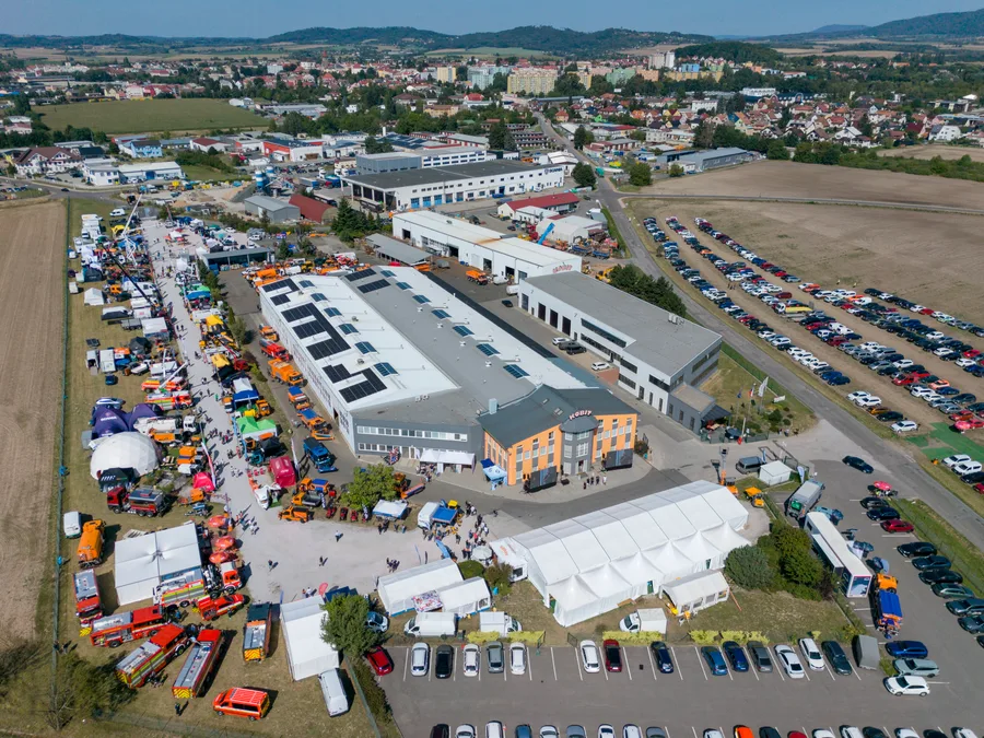 Areál KOBIT z výšky: haly s fotovoltaikou, aleje vystavené techniky, velký stan a zaplněná parkoviště